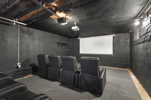 Cozy basement theater with projector & recliner seating—movie nights!