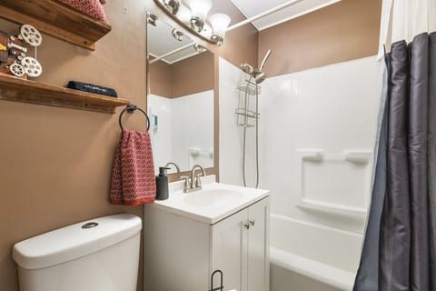 Bright, cozy bathroom with tub-shower combo and stylish modern vanity