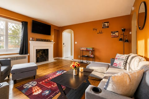 Bright, cozy living room with fireplace, TV, and plenty of seating