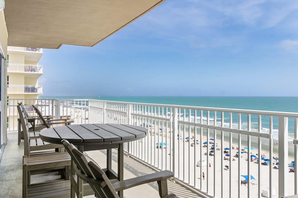 Private oceanfront balcony with seating and sweeping beach views