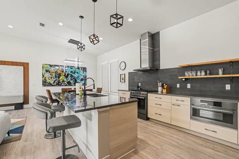 Sleek chef’s kitchen with waterfall island, bar seating, and open layout.