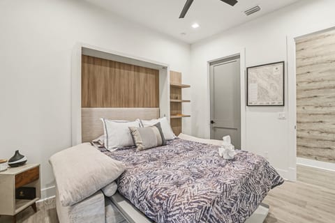 Modern room with queen Murphy bed, ceiling fan, and wood accents.
