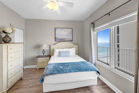 Spacious master bedroom with queen bed, dresser, and plenty of natural light.
