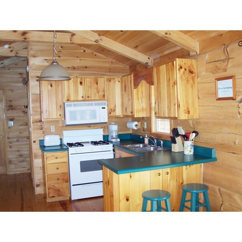 Kitchen with gas stove & oven, coffee maker, toaster & microwave. Tableware, pots, pans, utensils & glasses provided. Refrigerator with freezer is to the left of the photo.