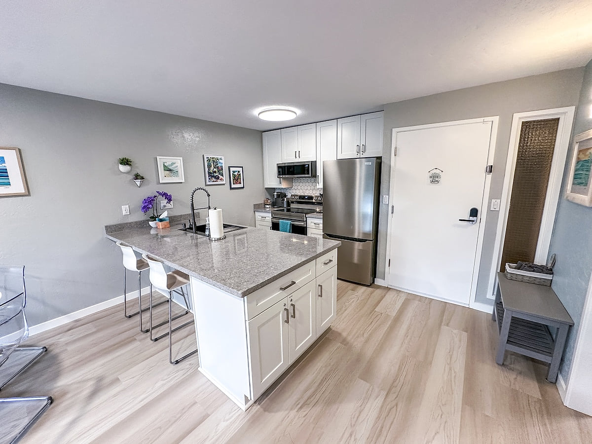 Completely renovated, fully-stocked, kitchen with large quartz island and full-size appliances.   Newly renovated Coconut Coast 1BR condo w/ A/C