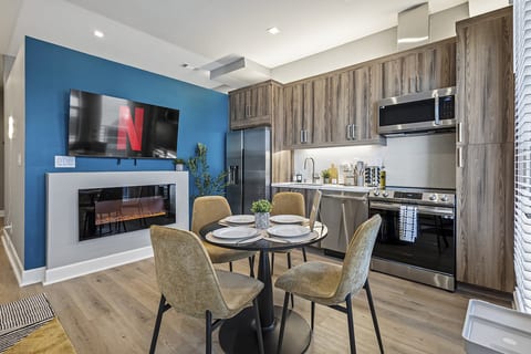 Cozy modern kitchen and dining area with smart TV and electric fireplace.