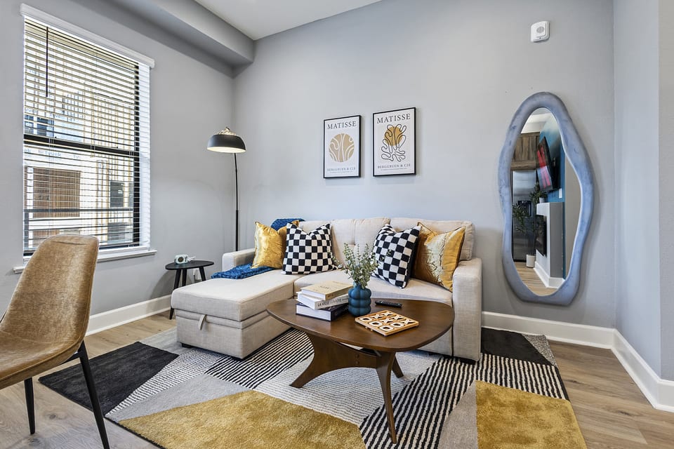 Charming living room with a cozy sofa, modern decor, and ample natural light.