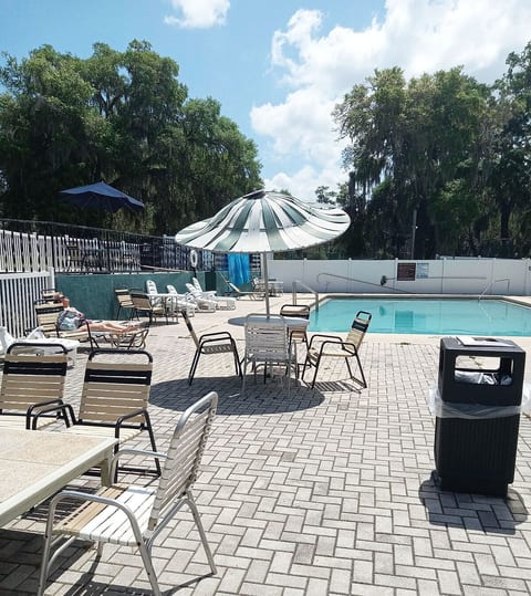 There is a lot of lounging chairs around the pool.