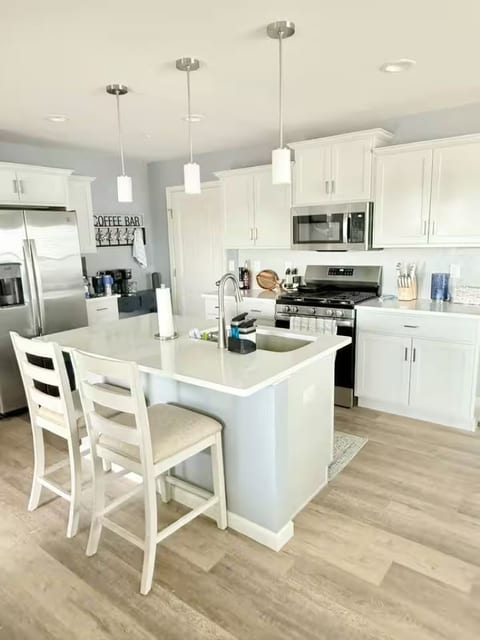 Bright modern kitchen with island seating, stainless appliances, and coffee bar