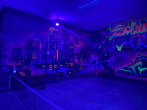 Custom painted glow room in the garage with pickleball and basketball court