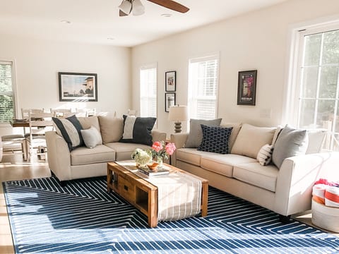 Sunny living room with large french doors opening up right to the pool.
