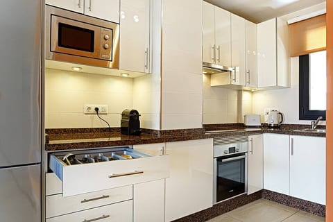 Fully equipped kitchen with stainless steel appliances, cookware, and Nespresso machine.