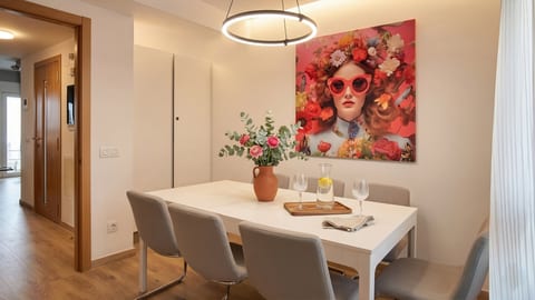Bright dining nook with modern ring light, bold art, and seating for four