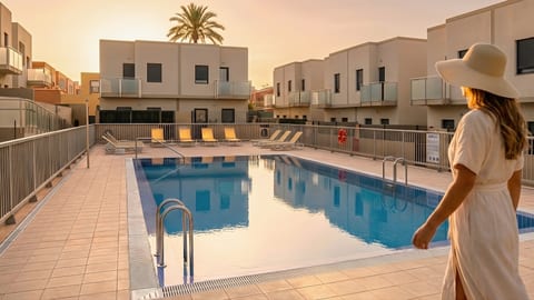 Modern complex with sunset pool, loungers, and private balconies