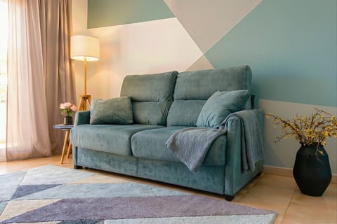 Cozy, light-filled lounge with plush sofa and chic geometric accents