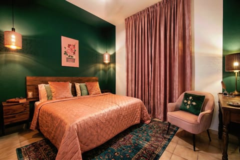 Emerald-chic bedroom with blush accents, pendant lights, and a plush queen bed