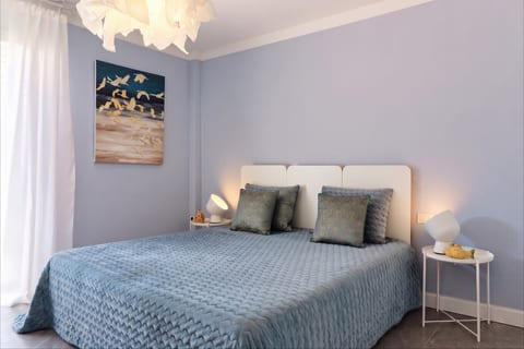 Serene blue bedroom with plush bedding, soft lighting, and artful decor