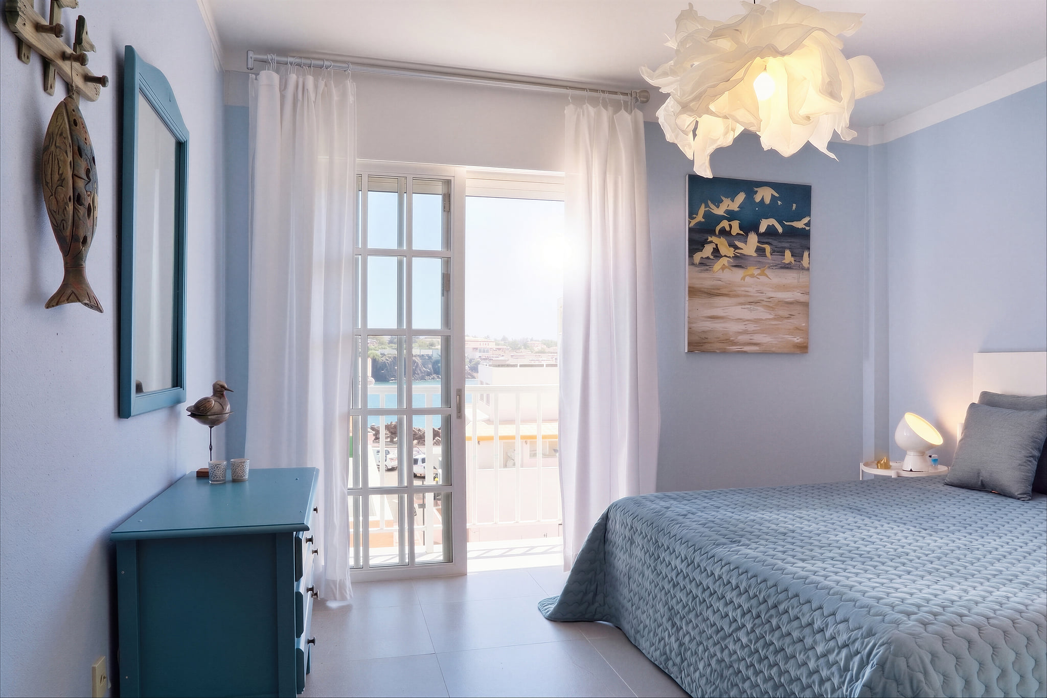 Airy coastal bedroom with balcony and sea view, serene and bright