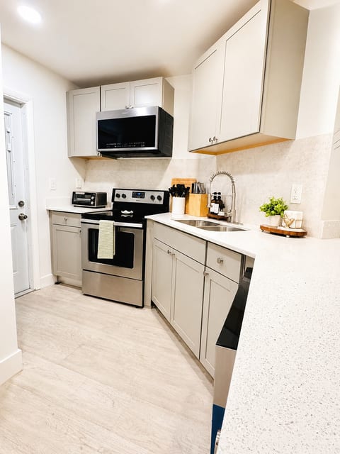 Fully equipped kitchen with modern appliances and cookware.
