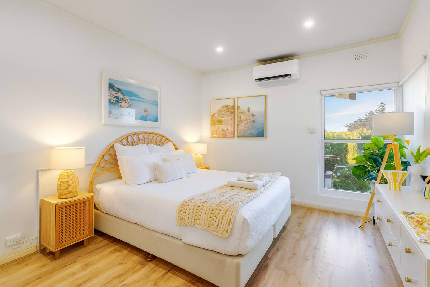 Sleep soundly on a plush queen bed amid pastel art and morning sun streaming through picture windows.