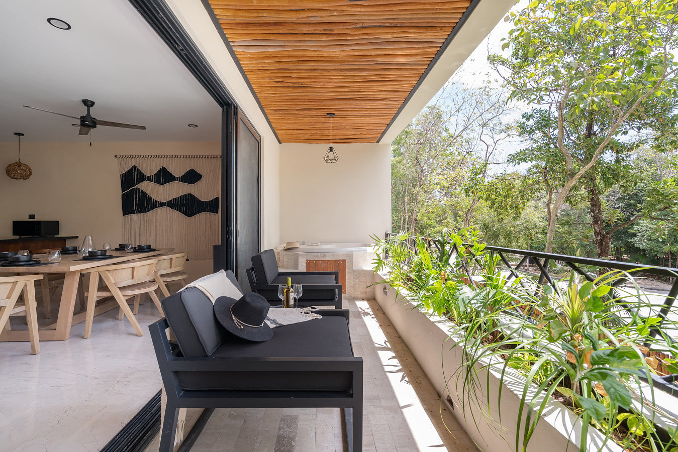 Spacious outdoor terrace with cozy seating, a jacuzzi, and jungle views. An inviting space to unwind, enjoy fresh air, and experience indoor-outdoor living.