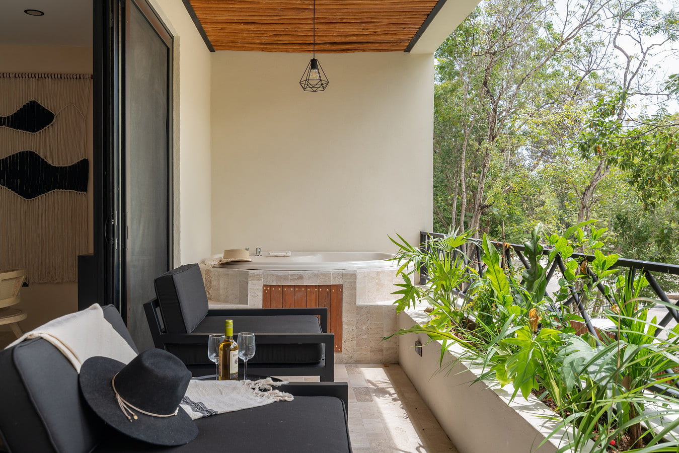 Spacious balcony featuring a jacuzzi, comfortable seating area, and tropical plants. An ideal spot to relax, soak, and enjoy peaceful jungle surroundings.