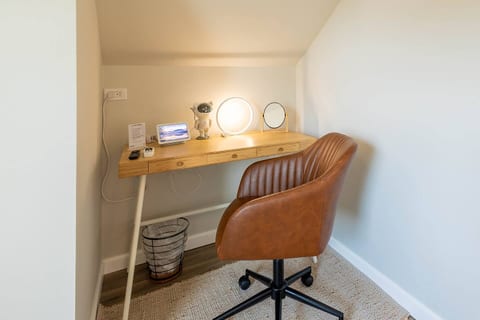 Dedicated work nook with warm lighting, comfortable swivel chair, and thoughtful desk setup—quiet, cozy, and ideal for focused work or planning your next adventure.