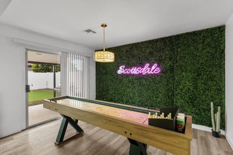 Indoor shuffleboard game room with signature Scottsdale neon sign
