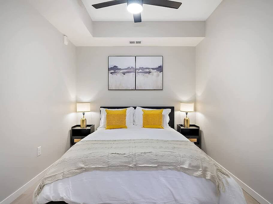 Relax in a serene bedroom with a king bed, soft linens, modern decor, and warm lighting!