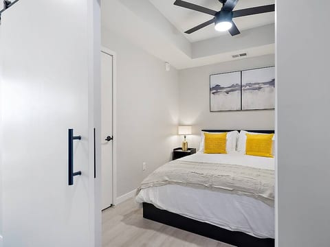 Elegant bedroom with sliding barn door, king-size bed, and warm, inviting lighting.