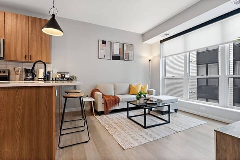 A bright, modern retreat with a sleek kitchen, cozy seating, and large sunny windows.