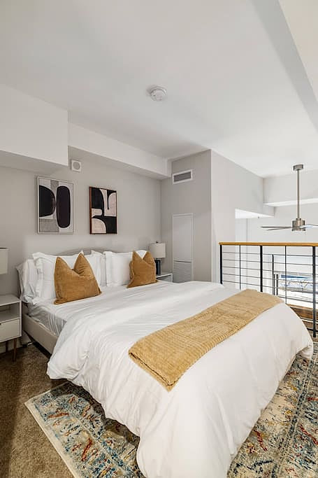 Cozy loft bedroom with modern decor, plush bedding, and a warm, inviting vibe
