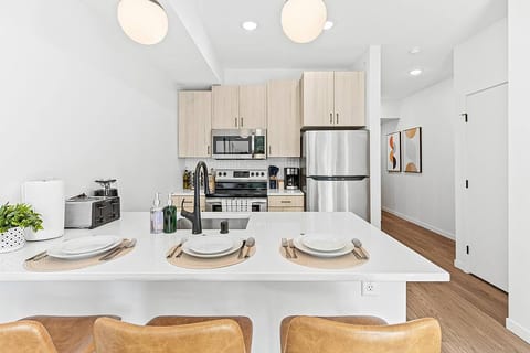 Bright, modern kitchen with stainless steel appliances, island seating, and style