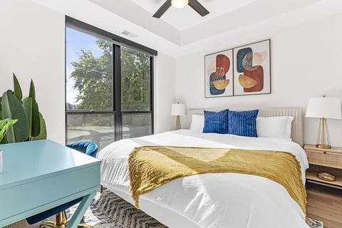 Relax in a serene bedroom with a plush king bed, natural light, and modern touches.