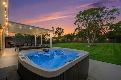 "Picture this: A six-person hot tub, a covered patio, and glowing bistro lights under a sky on fire. This is your perfect Navarre sunset—and the ultimate Florida evening is just one click away. Book your stay now."