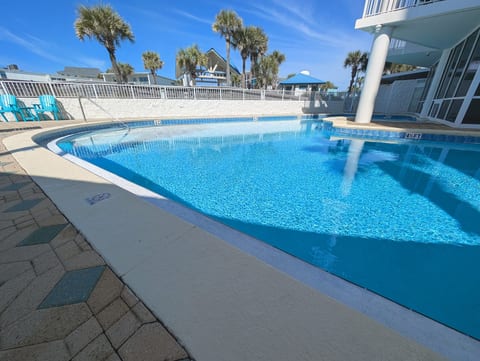Sparkling resort pool with palms, loungers, and easy step-in entry