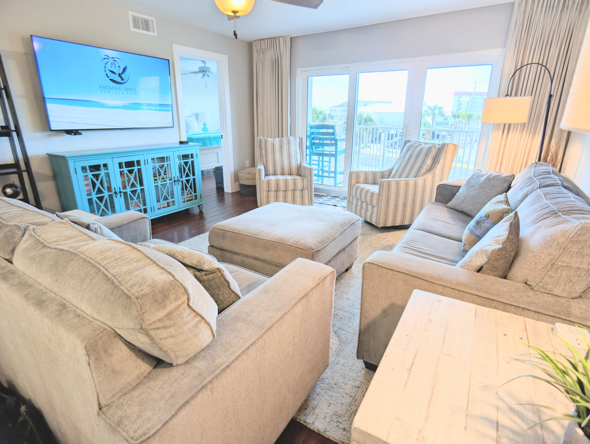 Coastal living room with balcony seating, views, and a big smart TV