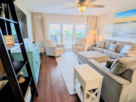 Coastal family room with balcony and palm views near the beach.