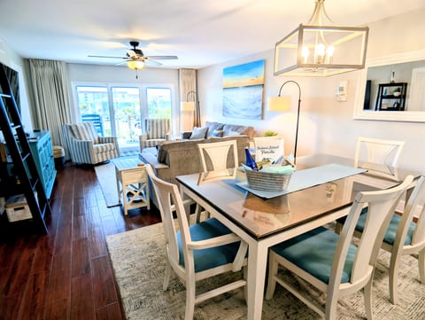 Bright coastal living room with dining space and private balcony access