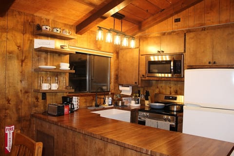 Kitchen equipped with all new appliances - microwave oven, oven range, dishwasher and new farmhouse sink. Plenty of dishes, bowls, forks, spoons, stainless steel cooking pans for healthy cooking. 