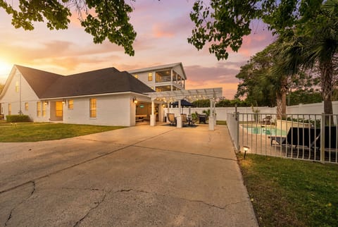 Sunset exterior with private pool, covered patio, and spacious driveway