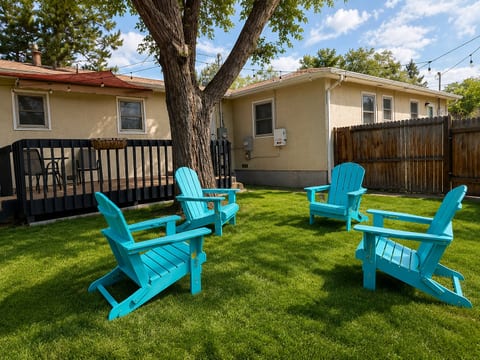 Private fenced backyard with shade tree, deck, and cozy outdoor seating