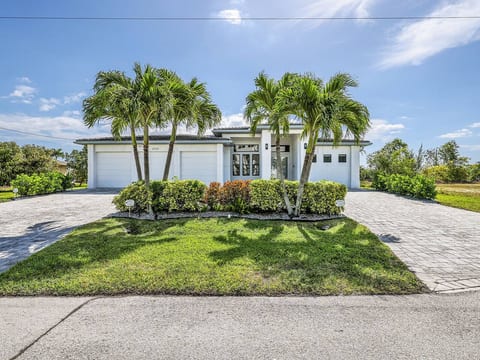 A beautiful first impression with modern coastal curb appeal, palm trees, and easy access to your Southwest Florida vacation home.