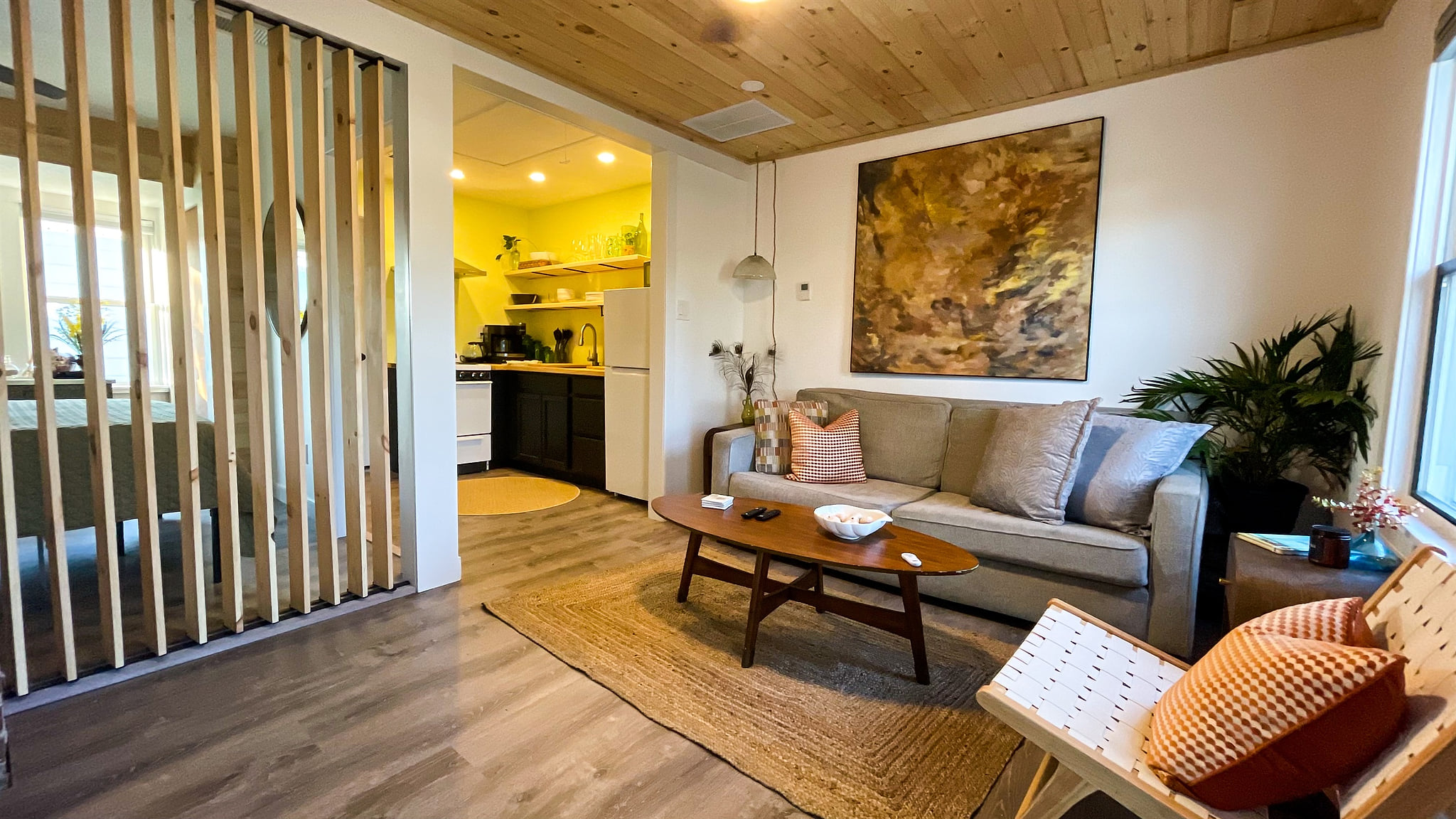 The wooden slat wall in the living room opens and closes for light and privacy