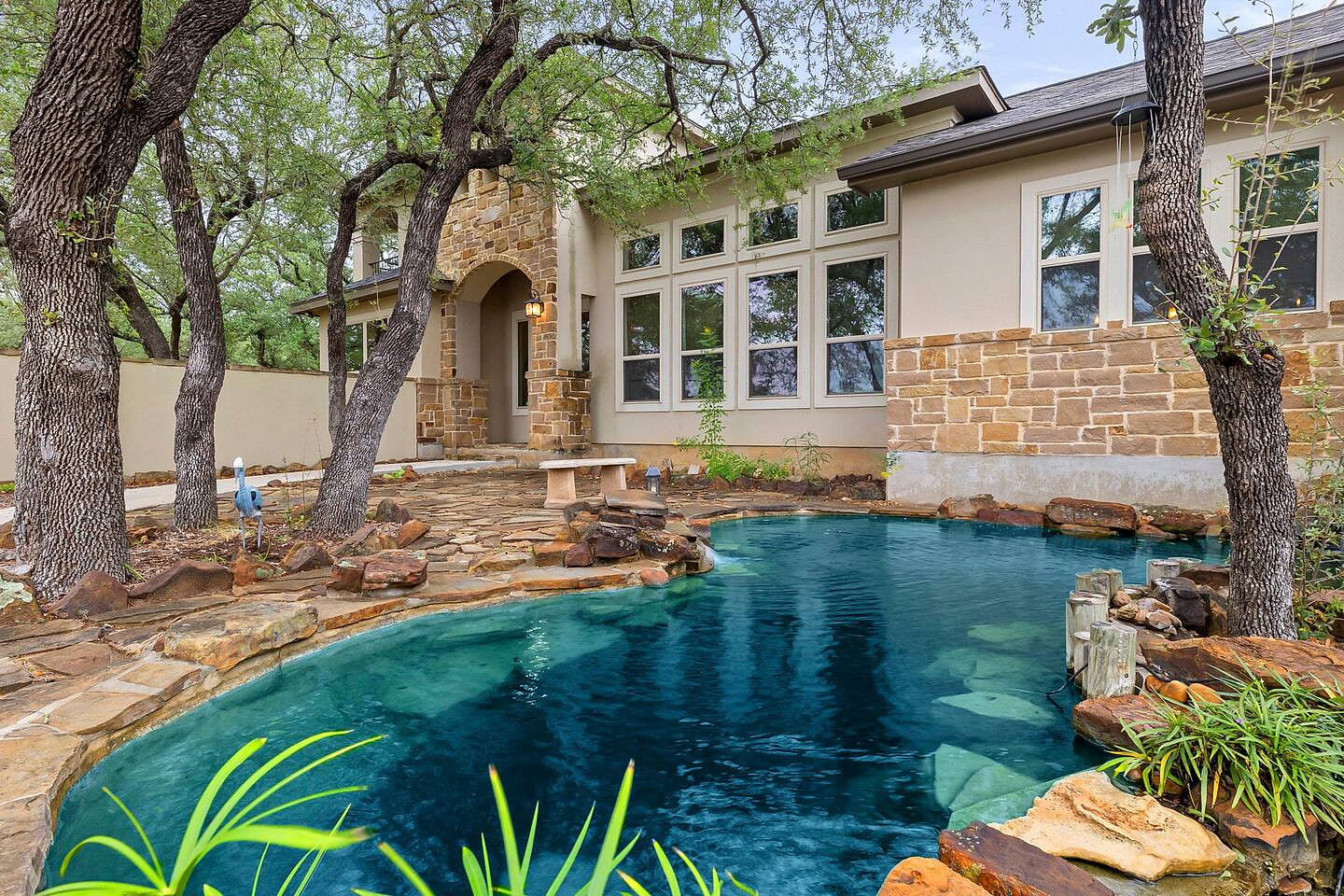 Natural pond beside the home with stone edging—not a swimming pool.