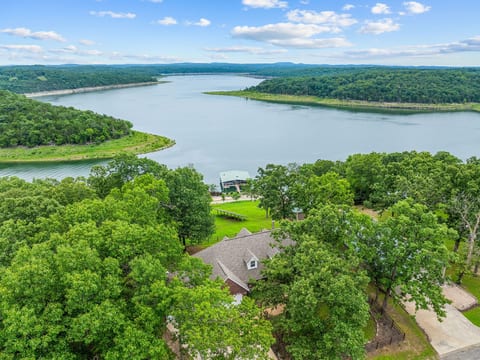 This is what you came for: Bull Shoals Lake visible through the trees behind the house, framed by Ozark hills on every side.