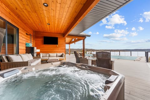 Unwind in a steaming hot tub on a covered lakefront deck, where sunset views, gentle breezes, and total privacy create an unforgettable escape.