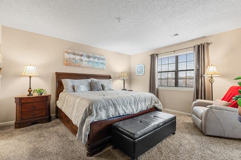 Guest bedroom with queen bed and warm lighting.