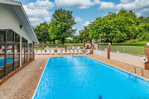 Outdoor pool and lounge area surrounded by Ozark greenery, open seasonally.