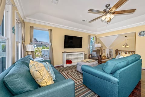 Living room with TV, 2 brand new full couches, ottoman with hidden blankets and a lazy chair.